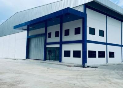 Large industrial warehouse exterior with blue and white facade