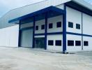 Large industrial warehouse exterior with blue and white facade