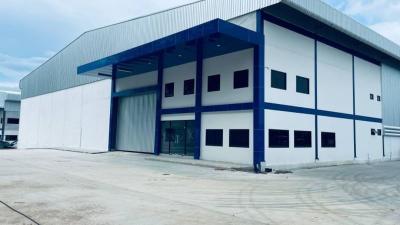 Large industrial warehouse exterior with blue and white facade