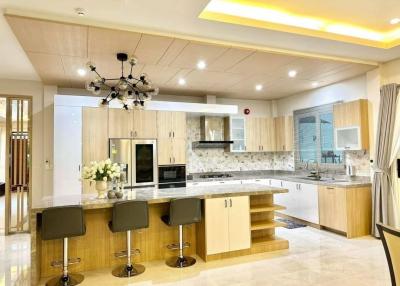 Modern spacious kitchen with bar stools and pendant lighting