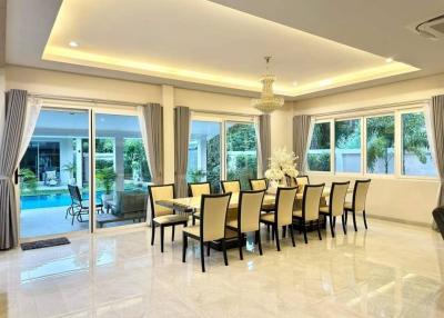 Spacious modern dining room with large table, chandelier, and access to patio