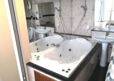 Spacious bathroom with modern jacuzzi tub and independent sink