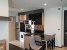 Modern kitchen with stainless steel appliances and a small dining area