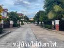 Paved street within a peaceful residential neighborhood lined with houses and lush greenery