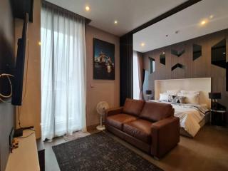 Modern bedroom with stylish interior design including a brown leather sofa and king-sized bed