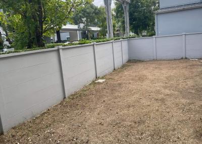 Empty backyard area with a boundary wall and a grassless ground
