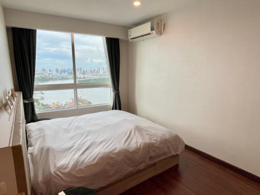 Spacious bedroom with a large window offering a city view