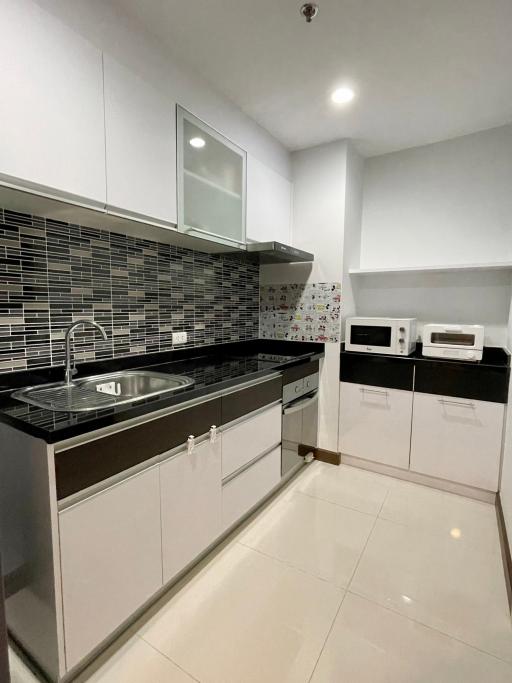 Modern kitchen with white cabinets and black backsplash