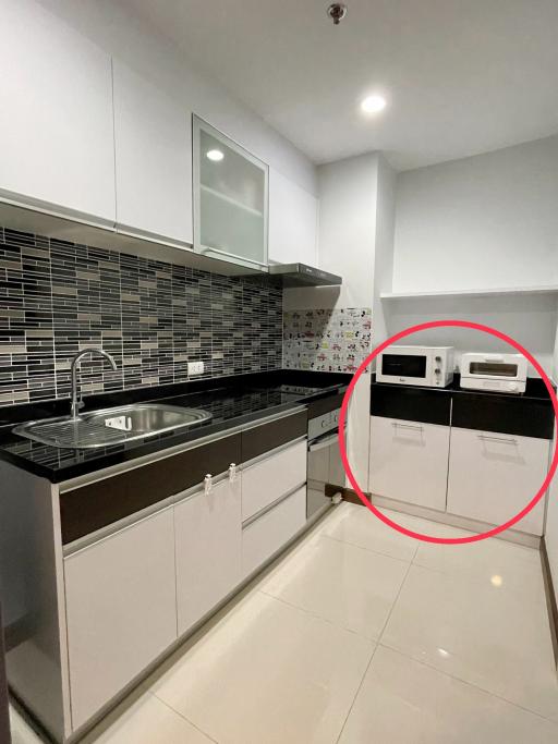 Modern kitchen with stainless steel sink and black tile backsplash