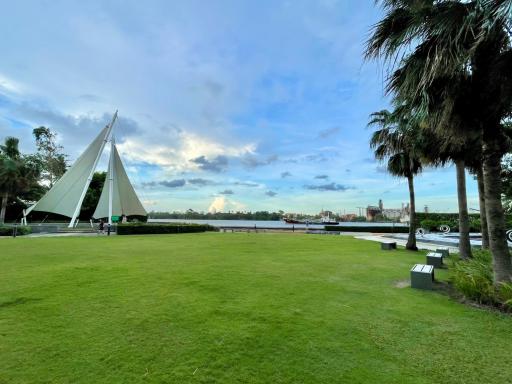 Spacious outdoor area with green lawn and a unique triangular structure under a blue sky