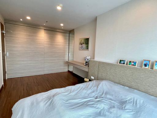 Modern bedroom with wooden floor and artwork