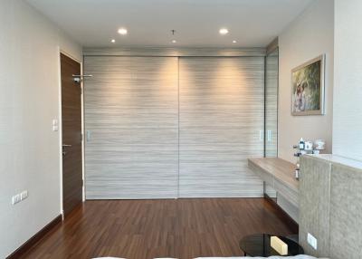 Modern bedroom interior with wooden flooring, built-in wardrobe, and study desk