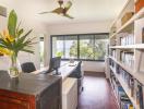 Bright home office with large windows and a bookshelf