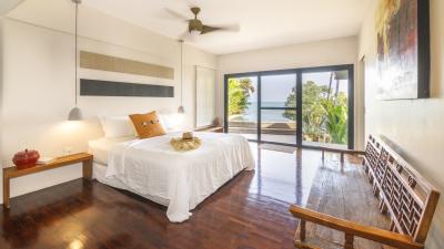 Spacious bedroom with a scenic ocean view, hardwood floors, and a large window