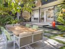 Outdoor dining space with large wooden table and comfortable seating in a lush garden