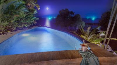 Elegant outdoor pool overlooking the night sky with a full moon reflecting on the water