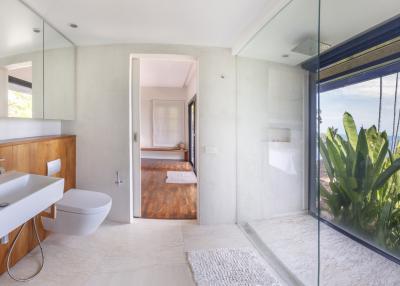 Modern bathroom with large window overlooking greenery