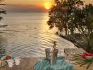 Luxurious infinity pool overlooking the ocean at sunset with refreshments