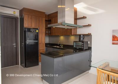 Modern kitchen with stainless steel appliances, floating shelves, and glossy countertops