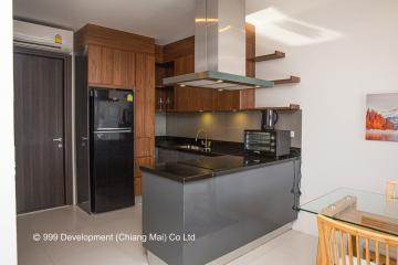 Modern kitchen with stainless steel appliances, floating shelves, and glossy countertops