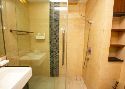 Modern bathroom interior with walk-in shower and beige tiles