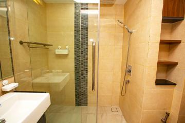 Modern bathroom interior with walk-in shower and beige tiles
