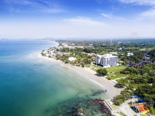 Aerial view of beachfront property with clear blue waters and surrounding greenery
