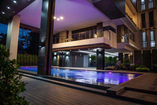 Luxurious outdoor pool area with ambient lighting in the evening