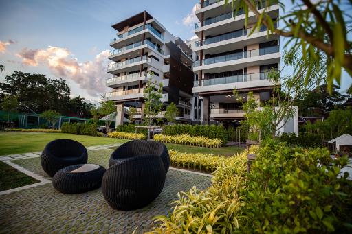 Modern residential buildings with outdoor green space and lounge chairs