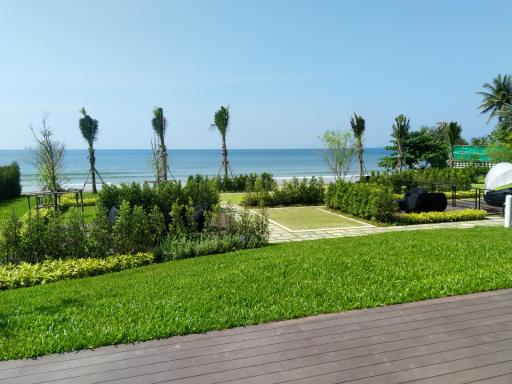 Ocean view from the garden with lush green lawn and wooden deck