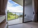 Bedroom with a view of the sea through a glass door leading to a balcony