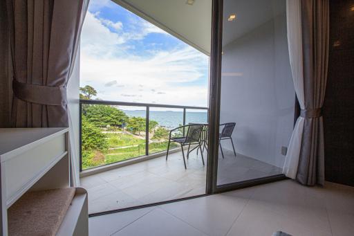 Bedroom with a view of the sea through a glass door leading to a balcony