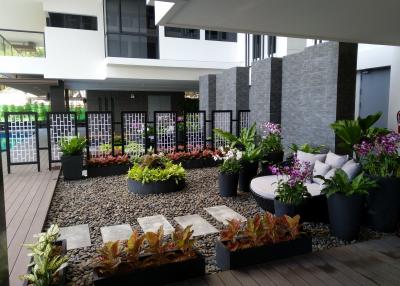 Well-maintained outdoor common area with seating and garden in a residential building complex
