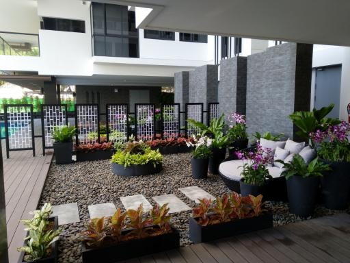 Well-maintained outdoor common area with seating and garden in a residential building complex
