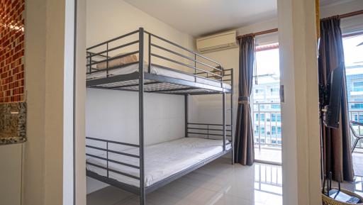 Compact bedroom with bunk bed and balcony access