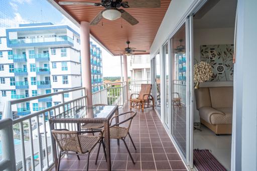 Spacious balcony with outdoor furniture and a ceiling fan overlooking the city