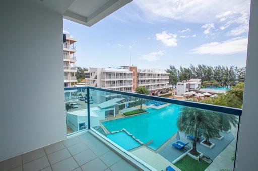 Spacious balcony overlooking a pool and the city skyline