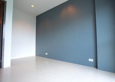 Spacious empty room with grey walls and tiled floor