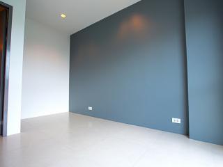 Spacious empty room with grey walls and tiled floor