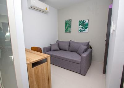 Contemporary cozy living room with a comfortable grey sofa and modern art on the wall