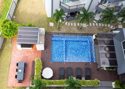 Aerial view of a residential backyard with swimming pool and patio