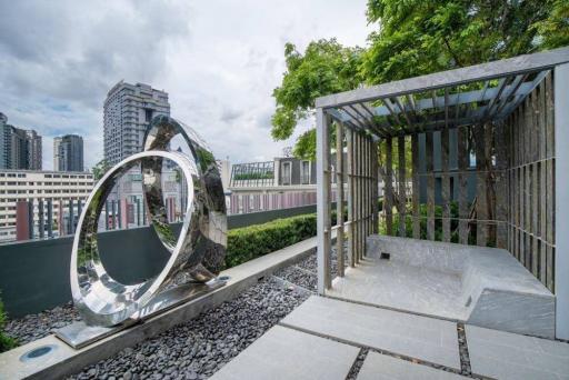 Modern rooftop garden with artistic sculptures and city view