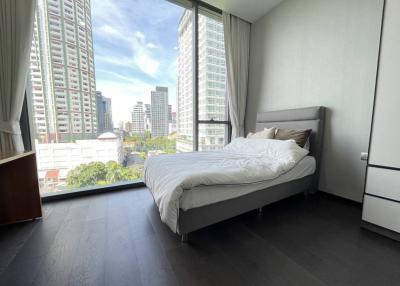 Spacious bedroom with a large window and city view