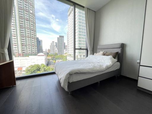 Spacious bedroom with a large window and city view