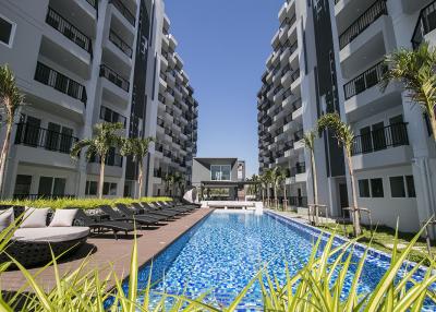 Luxury apartment complex with a spacious pool area and loungers