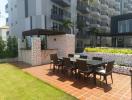 Modern outdoor communal area with poolside dining set and a pergola