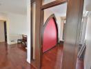 Elegant interior archway leading to a bright and spacious living area with wooden flooring