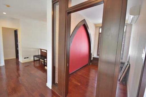 Elegant interior archway leading to a bright and spacious living area with wooden flooring