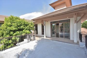 Spacious balcony with railing and a view of greenery outside a residential home