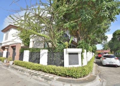 Exterior view of a two-story house with a garden and parking space